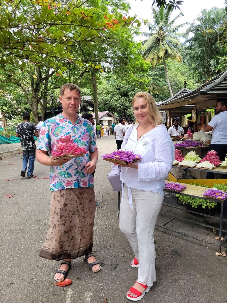 Couple buying lotus flowers for a temple offering