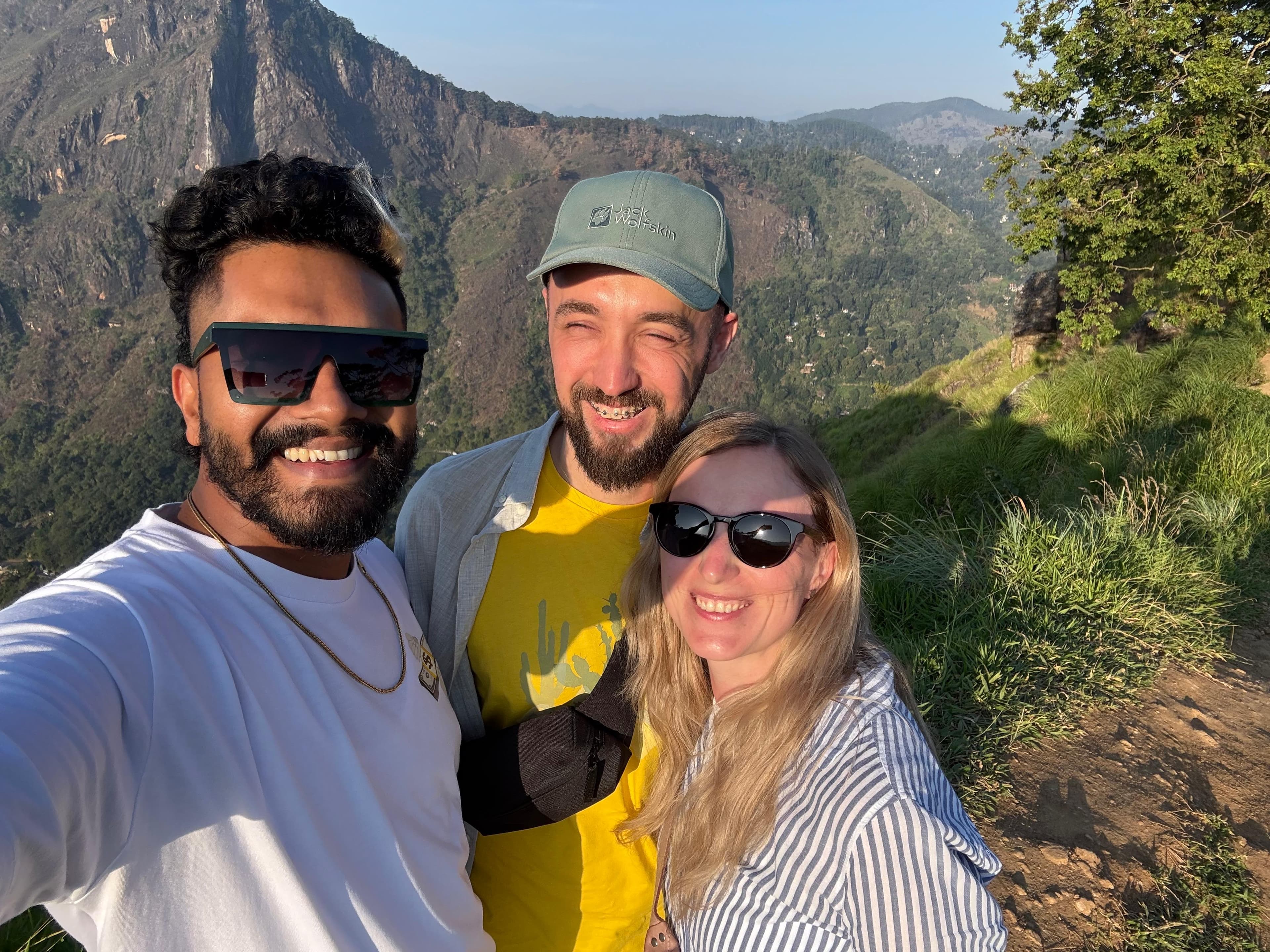 Guide and guests taking a selfie on a ridge at golden hour