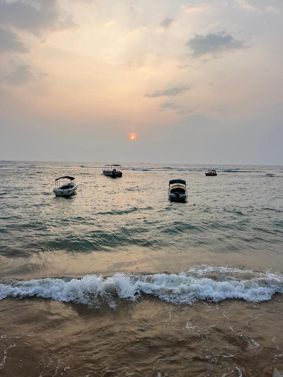 Fishing boats on the beach at sunset