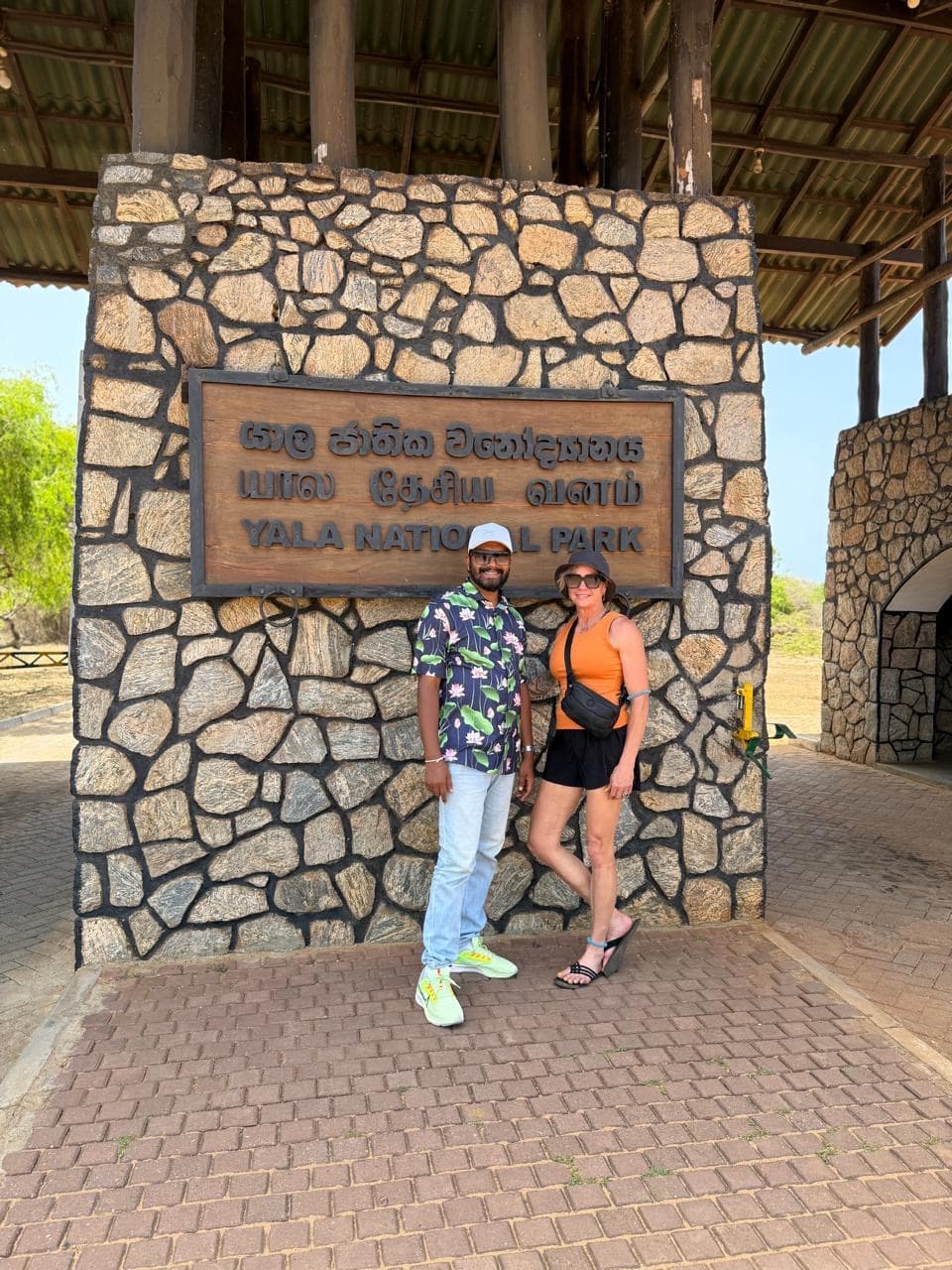 Guide and guest at the Yala National Park entrance sign