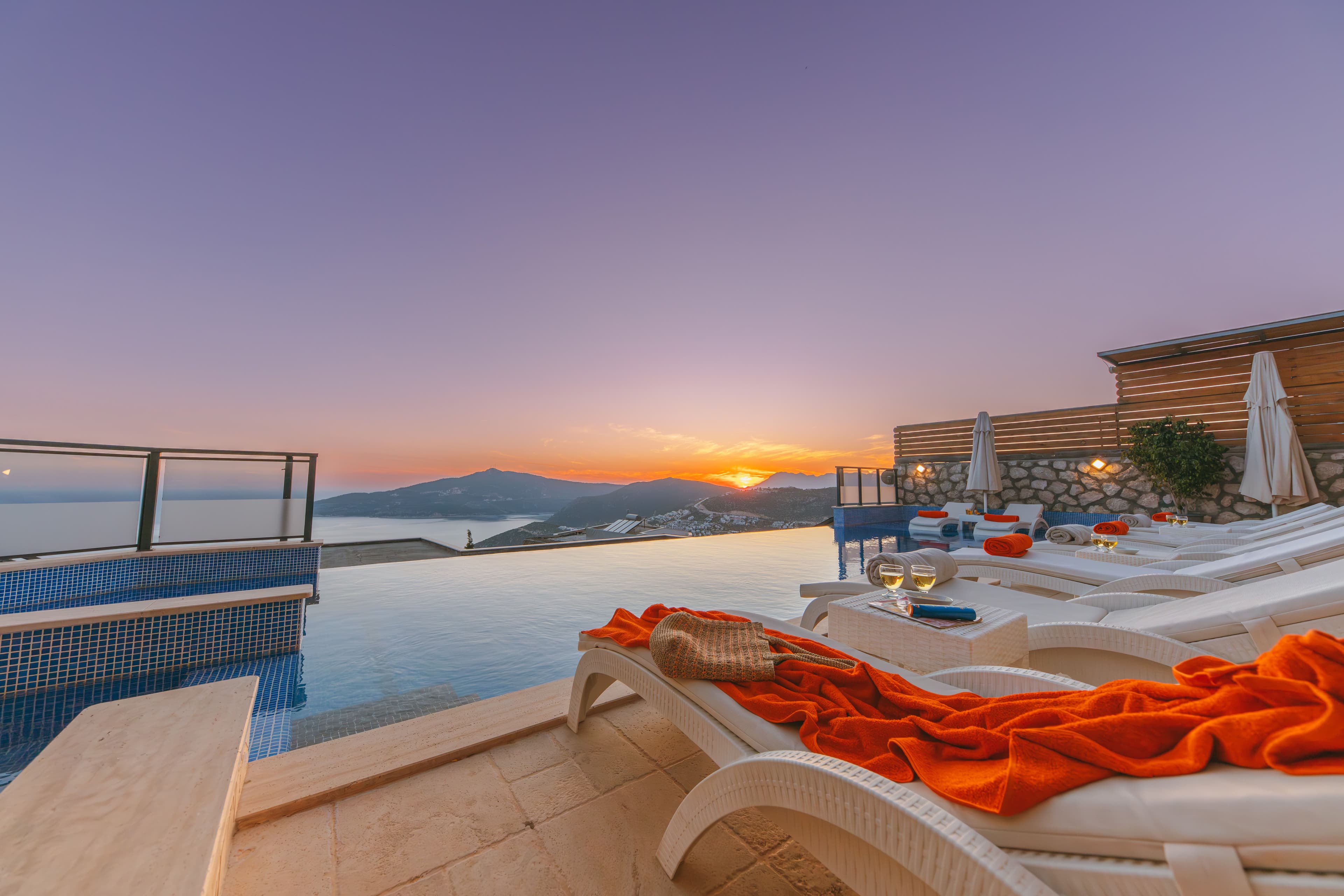 A private villa infinity pool overlooking the coast at sunset